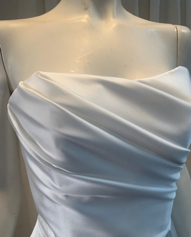 Elegant draped satin corset dress with a bold high split – the perfect balance of glamour and sophistication. Designed by Rikke Gudnitz