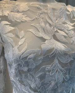 A refined two-piece set featuring a delicate lace top with long sleeves, paired with a flowing duchess satin skirt. Designed by Rikke Gudnitz.