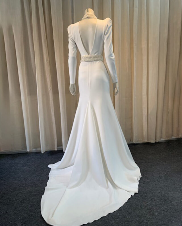 Couture dress in crepe, featuring a handmade beaded pearl belt and a matching pearl-embellished neckline, both crafted with exquisite attention to detail. Designed by Rikke Gudnitz herself.