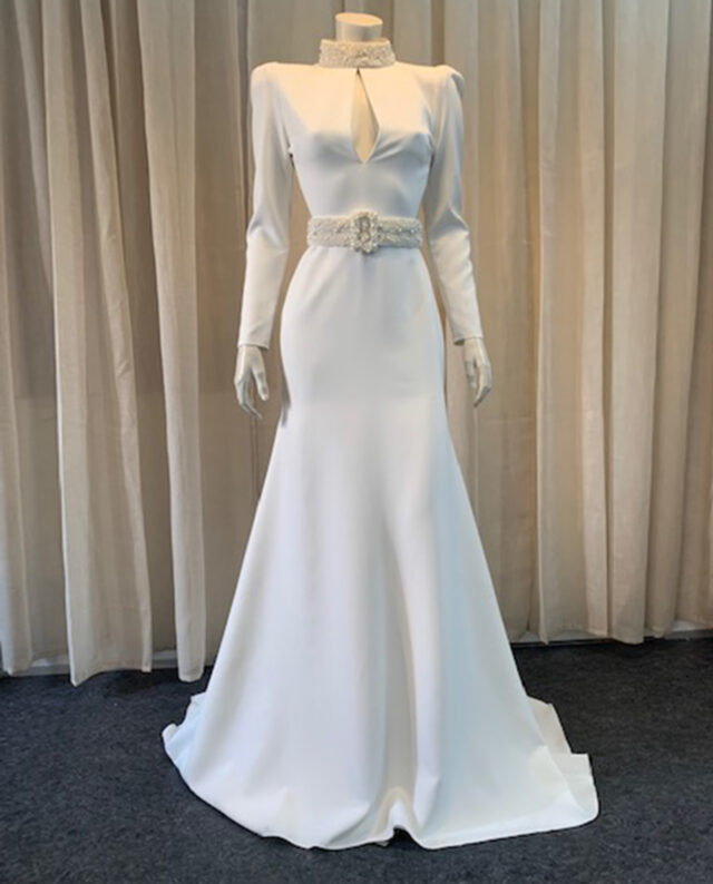 Couture dress in crepe, featuring a handmade beaded pearl belt and a matching pearl-embellished neckline, both crafted with exquisite attention to detail. Designed by Rikke Gudnitz herself.